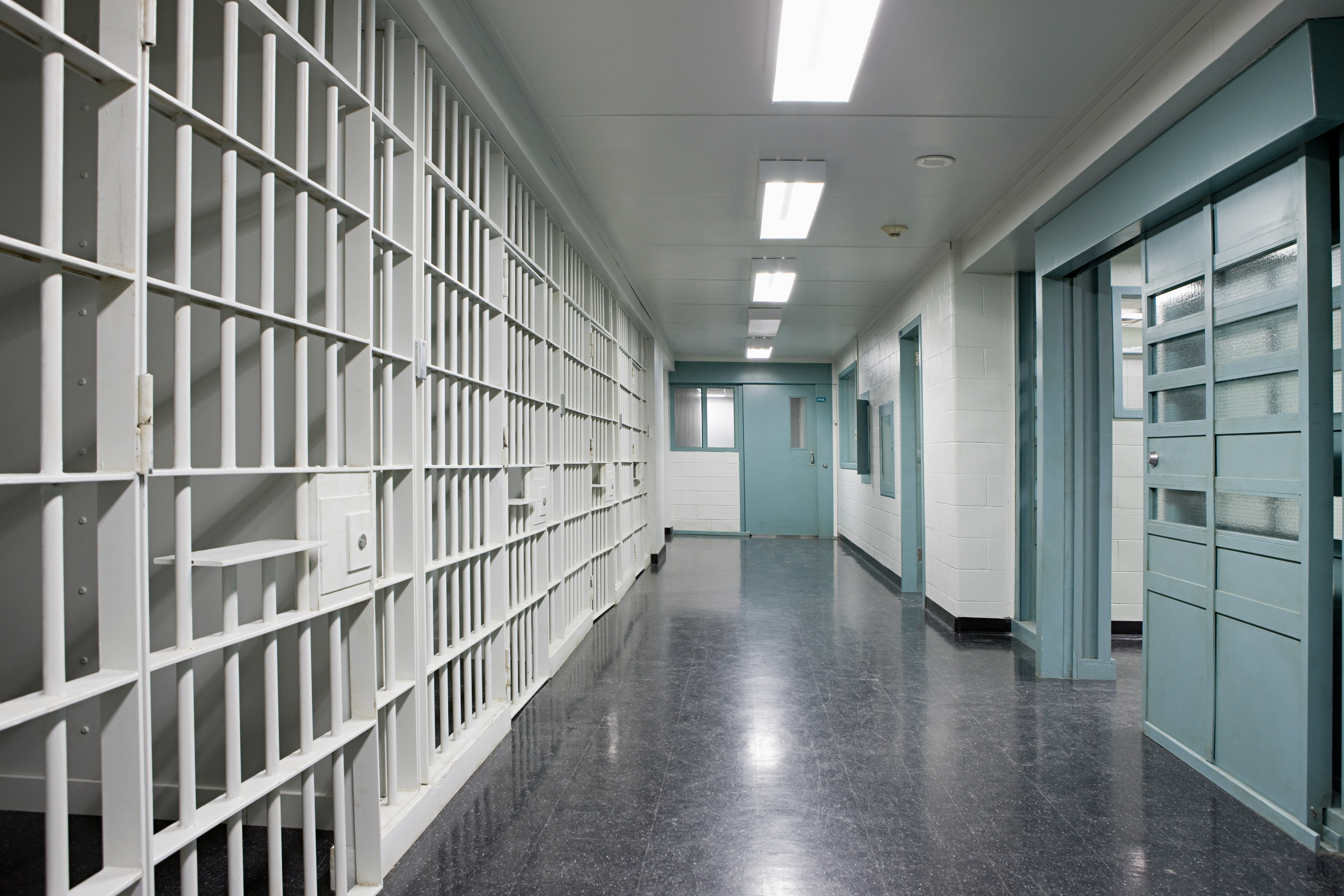 Prison corridor with a polished dark floor, showing the demanding environment where polyurethane flooring must perform reliably under constant operational pressure.